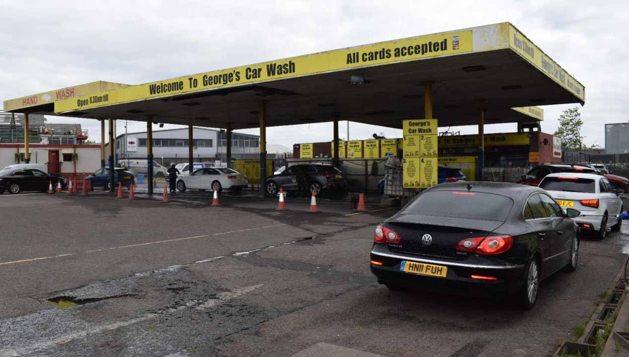 The covered wash bays at George's Car Wash on N Florida Road, Haydock, under the yellow 'Welcome to George's Car Wash' canopy