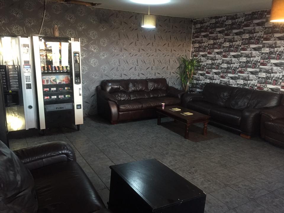 The customer waiting area at George's Car Wash with leather sofas and a vending machine